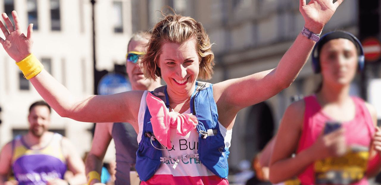A woman smiling and running